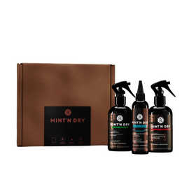 Three 'Mint N Dry' spray bottles in front of a brown box on a white background